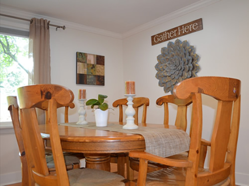 Broadview Adult Family Home dining room with decorative wall hanging that says Gather Here.